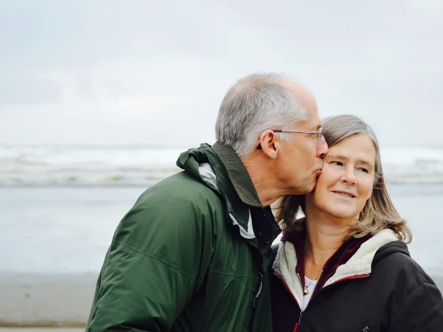 An older couple walking together at the beach