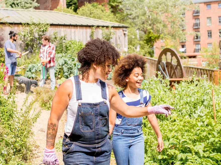Two people walking and talking together in a community garden
