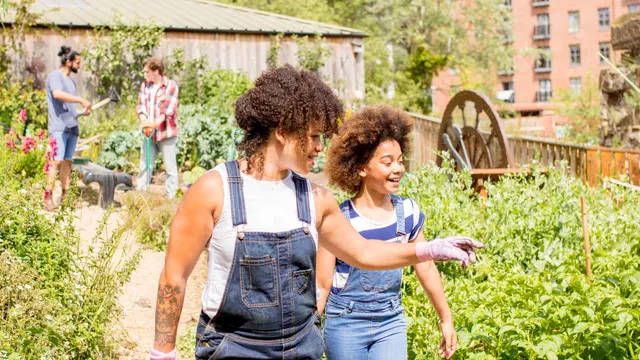 Two people walking and talking together in a community garden
